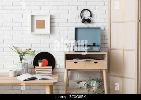 Das Innere des stilvollen Wohnzimmers ist mit Plattenspieler und Vinylplatten auf Holztischen ausgestattet Stockfoto