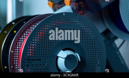 Jurmala, Lettland - 14.10.2025: Rotes Filament für 3D-Drucker Bambu Lab A1 mit AMS. Spulen mit farbigen Filamenten, die in einem 3D-Drucker verwendet werden, werden in einem angezeigt Stockfoto