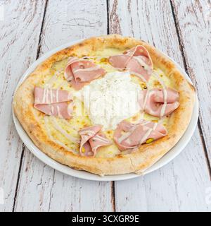 Carbonara Pizza mit Crème fraîche, knusprigem Speck, kandierten Zwiebeln und frisch geriebenem Parmesan Stockfoto