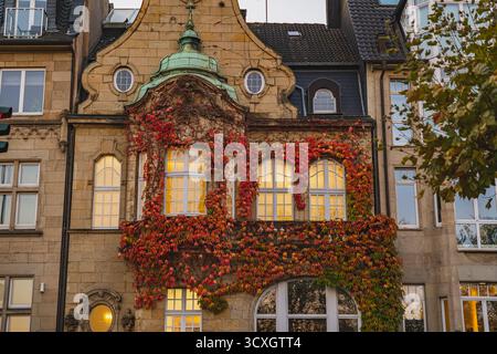 Das reich verzierte historische Gebäude im Düsseldorfer Stadtteil Oberkassel verfügt über elegante Fassaden, Bogenfenster und Efeupflanzen an der Fassade Stockfoto
