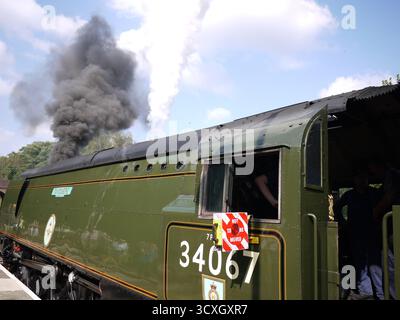 Dampflokomotive 34067 mit dramatischer schwarzer Rauchwolke gegen blauen Himmel Stockfoto