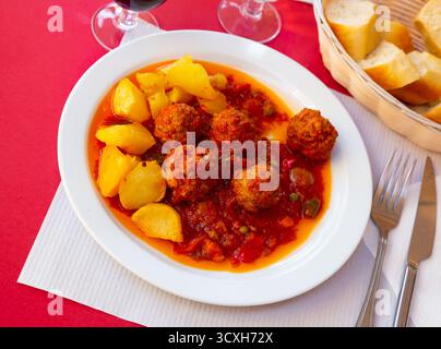 Spanische Fleischbällchen Albondigas in Tomatensauce mit gebackenen Kartoffeln Stockfoto