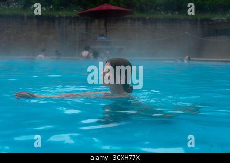 Frau, die sich in einer heißen Quelle entspannt und das wohltuende Wasser genießt. Radium Hot Springs, BC Stockfoto