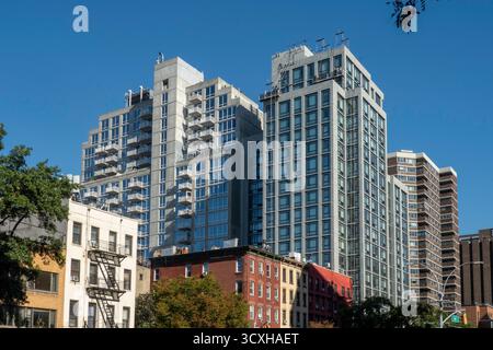 Hochhauswohnungen auf der E. 23rd St. stehen in krassem Kontrast zu den niedrigen Sandsteinen entlang der First Avenue, 2025, New York City, USA Stockfoto