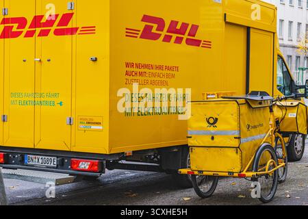 Gelber DHL-Lieferwagen mit Lieferfahrrad der Deutschen Post davor geparkt Stockfoto