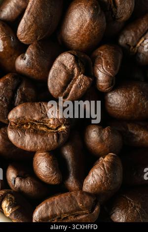 Vollbild-Nahaufnahme der gerösteten Kaffeebohnen, die das gesamte Bild füllen. Satte Textur und Erdtöne betonen Details, Wärme und natürliche Anmutung Stockfoto