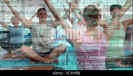 Der leitende Instruktor trägt ein pinkfarbenes Tanktop und führt die Schüler auf Yogamatten im Studio mit Code-Overlay Stockfoto
