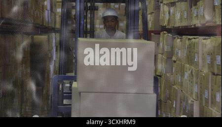 Betrieb des Gabelstaplers mit Helm und Schutzweste Transport der Palette im Lagergang zwischen Regalregalen Stockfoto