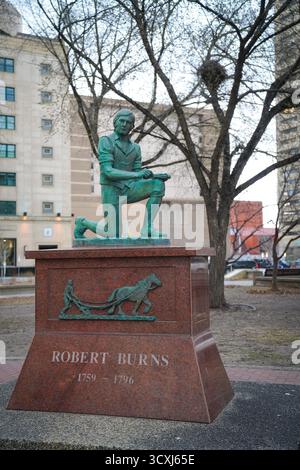 Edmonton, Alberta, Kanada – 27. April 2024: Die Bronzestatue des schottischen Dichters Robert Burns steht auf einem Sockel aus rotem Granit in einem Park in der Innenstadt Stockfoto