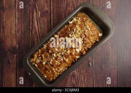 Hausgemachtes Bananenbrot mit Nüssen auf einem Holztisch Stockfoto