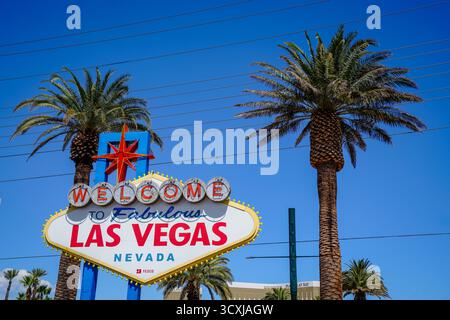 Das Schild „Welcome to Fabulous Las Vegas“, eingerahmt von hohen Palmen unter einem leuchtend blauen Himmel in der Nähe des südlichen Eingangs zum Las Vegas Strip Stockfoto