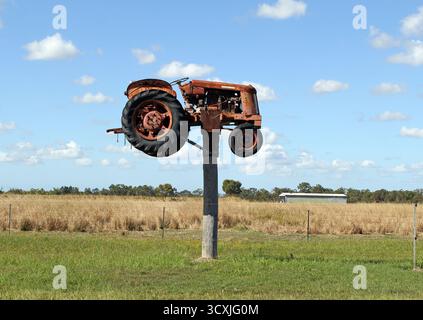 South Kolan, Queensland, Australien - 11. Juni 2024: Ein alter Traktor auf einem Holzpfosten montiert als Teil der Touristenattraktion Jim's Row of Machinery Stockfoto