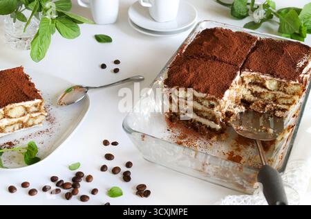 Tiramisu. Klassisches Kaffee-Tiramisu mit Marienfinger und Mascarponcreme, bestreut mit Kakaopulver auf weißem Hintergrund. Italienisches Dessert. Stockfoto