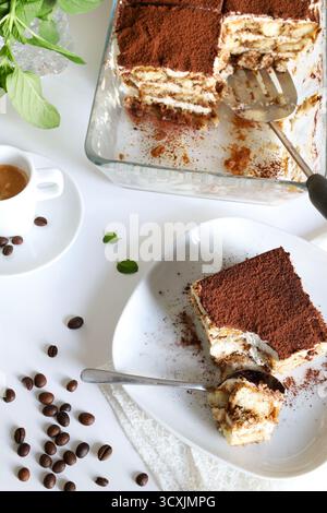 Tiramisu. Klassisches Kaffee-Tiramisu mit Marienfinger und Mascarponcreme, bestreut mit Kakaopulver auf weißem Hintergrund. Italienisches Dessert. Stockfoto