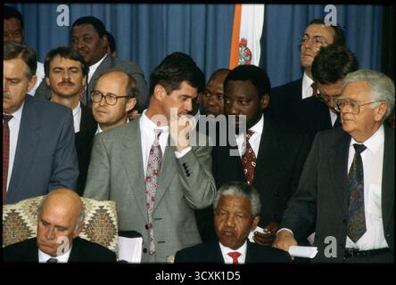 Südafrika Pretoria. Roelf Meyer (L) spricht mit Cyril Ramaphosa, als F.W. de Klerk (sitzend) und Mandela ankündigen, dass die IFP sich der ersten Wahl der SA angeschlossen hat. Stockfoto