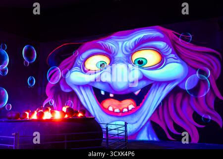 Halloween-Beleuchtung, gruselige Gruselszene, Herbstfest, Hexe und Kessel Stockfoto