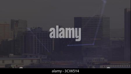 Die Skyline der Innenstadt zeigt in der Abenddämmerung leuchtend blaue Netzwerkverbindungen mit verglasten Bürotürmen Stockfoto