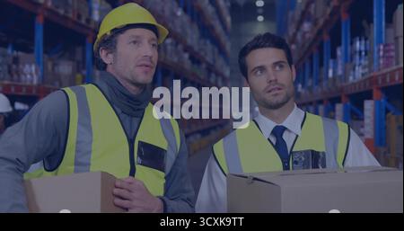 Inspektion von Kartonschachteln in Lagerregalen, zwei Männer mit reflektierenden Westen und Schutzhelmen Stockfoto