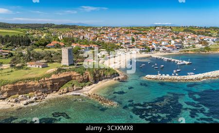 Drohnenansicht von Nea Fokaia in Chalkidiki, Griechenland, mit türkisfarbenem Wasser, Hafen, Fischerbooten, und die Küste im Sommerlicht. Stockfoto