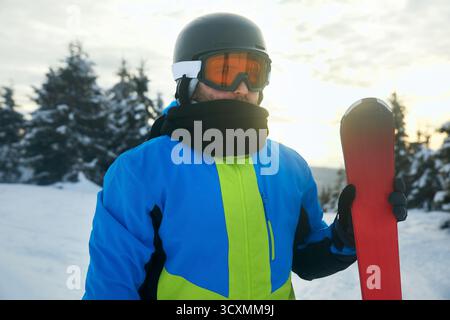 Porträt eines Skifahrers im Skigebiet vor dem Hintergrund der Berge und des blauen Himmels, Bukovel. Skibrille eines Mannes, der eine Skibrille trägt. Wintersport. Stockfoto