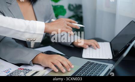 Nahaufnahme des Geschäftsteams, das an einem Notebook und Tablet arbeitet und ein Projekt diskutiert, das Konzept der Teamarbeit, digitale Strategie und moderne Geschäftskommunikation Stockfoto