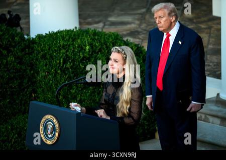 Erika Kirk überbringt eine herzliche Hommage, während Präsident Donald J. Trump bei der Zeremonie zu Ehren ihres verstorbenen Ehemanns Charlie Kirk mit der Presidential Medal of Freedom im Rose Garden des Weißen Hauses am 14. Oktober 2025 hinter ihr steht. Bild mit freundlicher Genehmigung des Weißen Hauses. Stockfoto