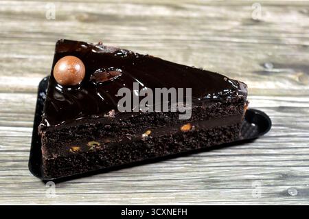 Fudge Cake Slice mit einer Schokoladenkugel, ein Schokoladenkuchen mit einer Konsistenz, einem Geschmack oder einem Reichtum, der an Fudge erinnert, ein mit mel aromatisierter Kuchen Stockfoto