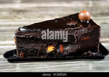 Fudge Cake Slice mit einer Schokoladenkugel, ein Schokoladenkuchen mit einer Konsistenz, einem Geschmack oder einem Reichtum, der an Fudge erinnert, ein mit mel aromatisierter Kuchen Stockfoto