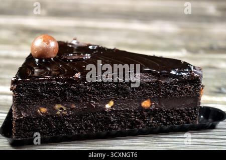 Fudge Cake Slice mit einer Schokoladenkugel, ein Schokoladenkuchen mit einer Konsistenz, einem Geschmack oder einem Reichtum, der an Fudge erinnert, ein mit mel aromatisierter Kuchen Stockfoto