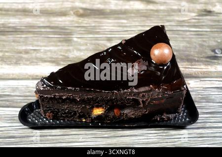Fudge Cake Slice mit einer Schokoladenkugel, ein Schokoladenkuchen mit einer Konsistenz, einem Geschmack oder einem Reichtum, der an Fudge erinnert, ein mit mel aromatisierter Kuchen Stockfoto