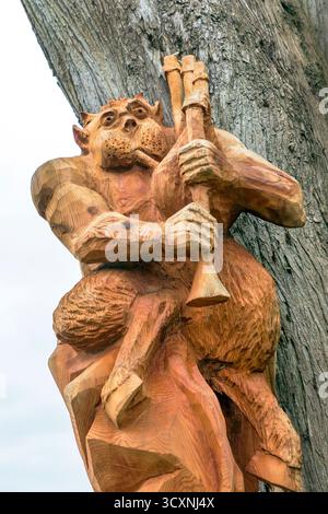 Figuren des Teufels, der den Dudelsack spielt, aus Robert Burns Gedicht Tam O'Shanter, in Holz geschnitzt und im Burns Gedenkgarten ausgestellt. Stockfoto