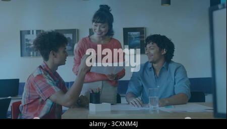 Mitarbeiter, die Dokumente an einem Besprechungstisch im Büro prüfen, mit Stiften und Laptop Stockfoto