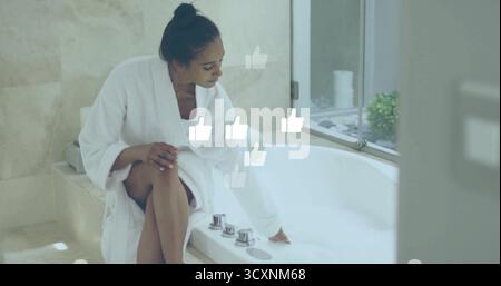 Eine angelehnte Frau mit weißem Bademantel, die den Wasserhahn auf der Wanne anpasst, füllt Blasen am Fenster, Kopierraum Stockfoto