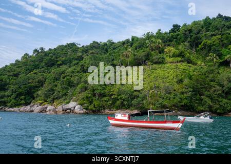 Zwei kleine Fischerboote ruhen auf dem Atlantischen Ozean und heben das ruhige Wasser der Insel, die üppige tropische Landschaft und den malerischen Horizont hervor Stockfoto