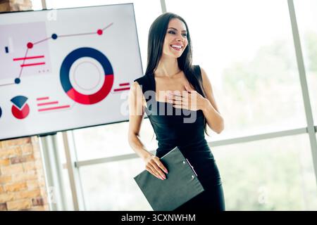 Elegante junge Geschäftsfrau, die sich im Büro mit professionellem Selbstvertrauen und positivem Verhalten am modernen Arbeitsplatz präsentiert Stockfoto