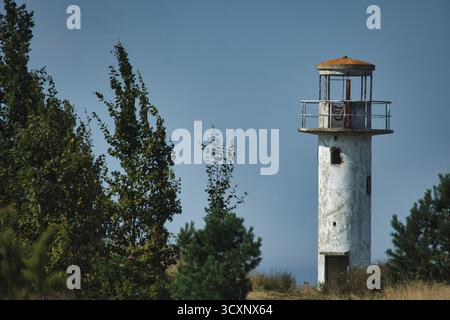 Verwitterter Neeme Leuchtturm an Estlands Küste, Standing Tall Against the Blue Sky Stockfoto