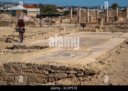 Touristen erkunden die Mosaiken und Ruinen im Paphos Archäologischen Park, Zypern. Stockfoto