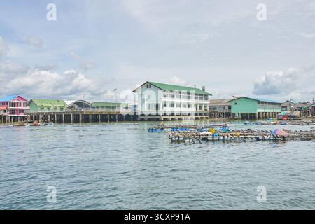 PHUKET, THAILAND - 12. NOVEMBER 2017: Küstendorf mit Pfahlbauten und ruhigem Wasser unter bewölktem Himmel. Stockfoto