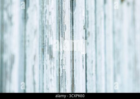 Nahaufnahme alter abblätternder Farbe auf vertikalen Holzbrettern, rustikale Hintergrundstruktur mit geringer Schärfentiefe. Stockfoto