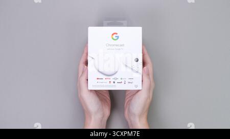 Google Chromecast-Streaming-Gerät in Händen mit schlankem Design und kompakter Verpackung, ideal für ein modernes Home-Entertainment-Erlebnis Stockfoto