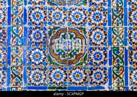 Ein lebhaftes Mosaik aus der Nähe eines traditionellen Mosaiks aus Keramikfliesen mit einer reichen Auswahl an geometrischen und floralen Mustern in Blau-, Grün- und Erdtönen Stockfoto