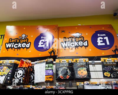 Manchester, Großbritannien - 26. September 2025: Buntes Halloween-Display mit leuchtenden orangefarbenen Schildern, gruseligen Skeletten und verspielten Dekorationen für Partyzubehör. Stockfoto