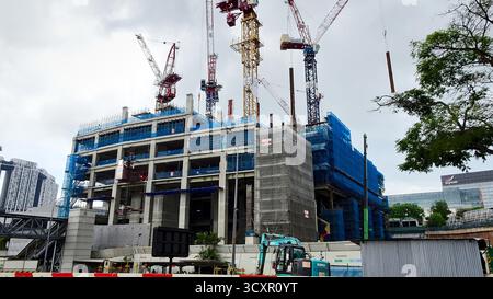 Bau eines neuen Hochhaus- und Geschäftsgebäudes in Singapur mit mehreren Kränen vor Ort. Stockfoto