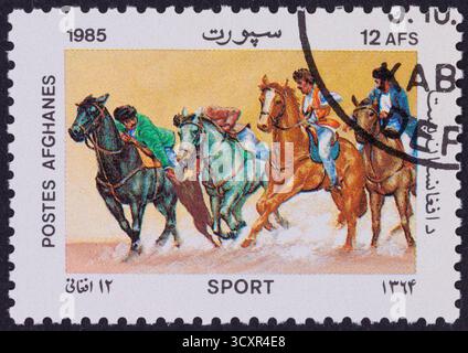 Eine Briefmarke von 1985, die ein Pferderennen mit vier Reitern darstellt. Stockfoto