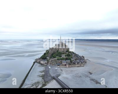 Mont saint-michel, eine historische befestigte Abtei und Gezeiteninsel in der normandie, frankreich, steht prominent auf einem Felsvorsprung mit umliegenden Sandbänken Stockfoto