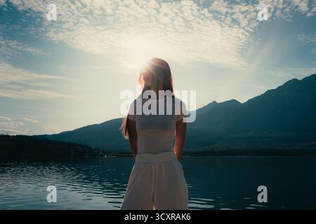 Frau in der Nähe des Wassers mit Bergen in der Ferne während des Tages. Pyramid Lake, Jasper, ab Stockfoto