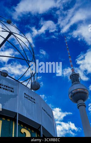 Weltzeituhr und Fernsehturm am Alexanderplatz – zwei Wahrzeichen unter einem hellen Sommerhimmel Stockfoto