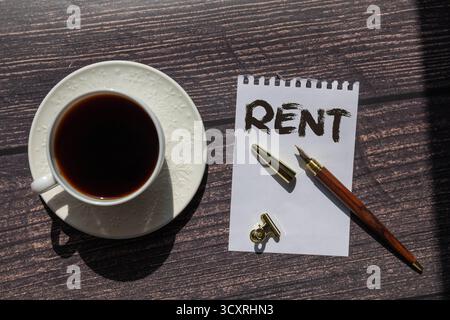 MIETE - Wort (Text) und Geld Dollar und Euro auf einem Tisch aus verschiedenen Farben, ein Notizblock und ein roter Bleistift. Geschäftskonzept, kaufen, verkaufen, tauschen Stockfoto