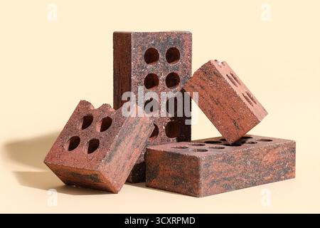 Orangefarbene Ziegelsteine auf beigem Hintergrund Stockfoto
