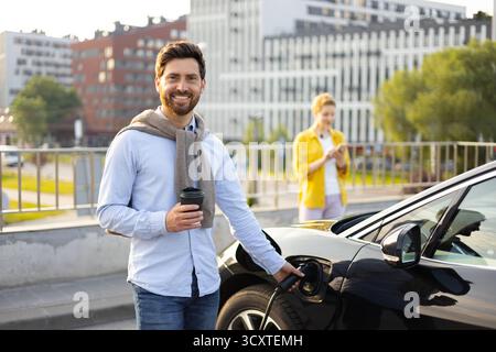 Man Lädt Elektroauto Auf Stockfoto